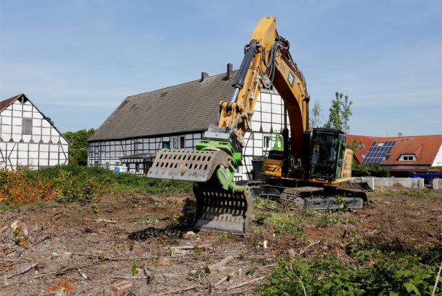Vor Fachwerkhäusern in Bergkamen steht ein Abrissbagger.