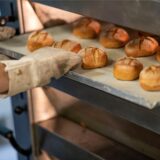 Auf dem Bild sind frisch gebackene Brötchen in dem Ofen einer Bäckerei zu sehen.