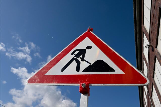 Ein Baustellenschild vor blauen Himmel.