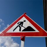 Ein Baustellenschild vor blauen Himmel.