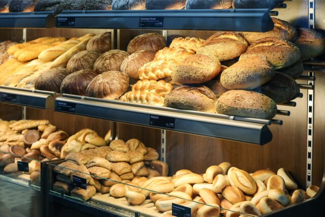 Brote und Brötchen liegen in einer Bäckerei-Theke aus.