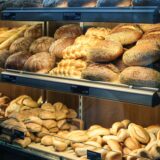 Brote und Brötchen liegen in einer Bäckerei-Theke aus.