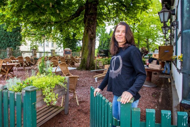 Tatjana Schüle steht in Herten-Westerholt auf dem Außengelände ihres Restaurants Alt Westerholt und öffnet die Tür zum Biergarten.