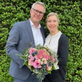 Carsten Wewers mit seiner Frau Indra. Sie halten einen Blumenstrauß in den Händen.