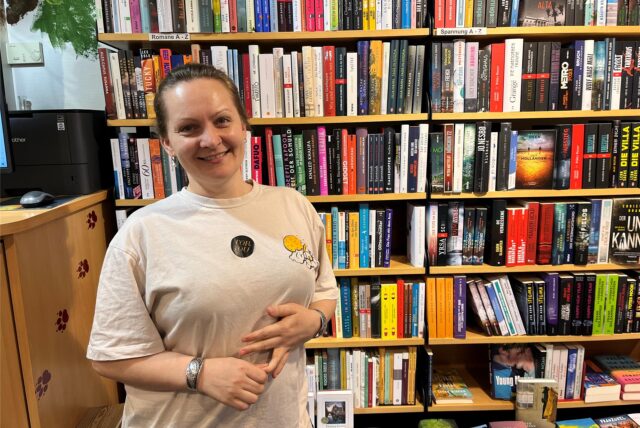 Natalia Tokar-Kahn lächelt in die Kamera, hinter ihr ein großes Bücherregal.