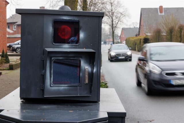 Ein Panzerblitzer steht am Straßenrand, zwei Pkw fahren an diesem vorbei. (Symbolbild)