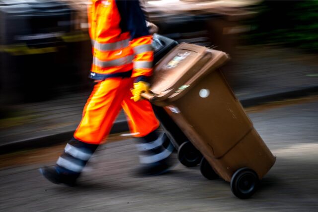 Restmüll und Biomüll wird von einem Müllwerker der Bremer Müllabfuhr abgeholt.