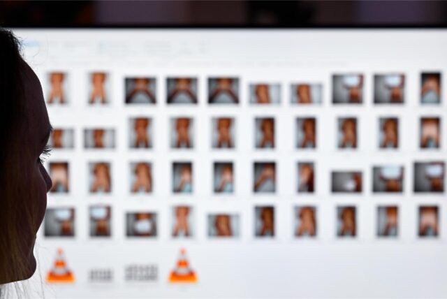 Symbolbild: Ein Ermittler sitzt vor einem PC, auf dem verpixelte pornografische Dateien abgebildet sind