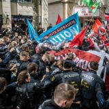 Schwarz uniformierte Polizisten und Demonstranten mit Flaggen geraten aneinander.