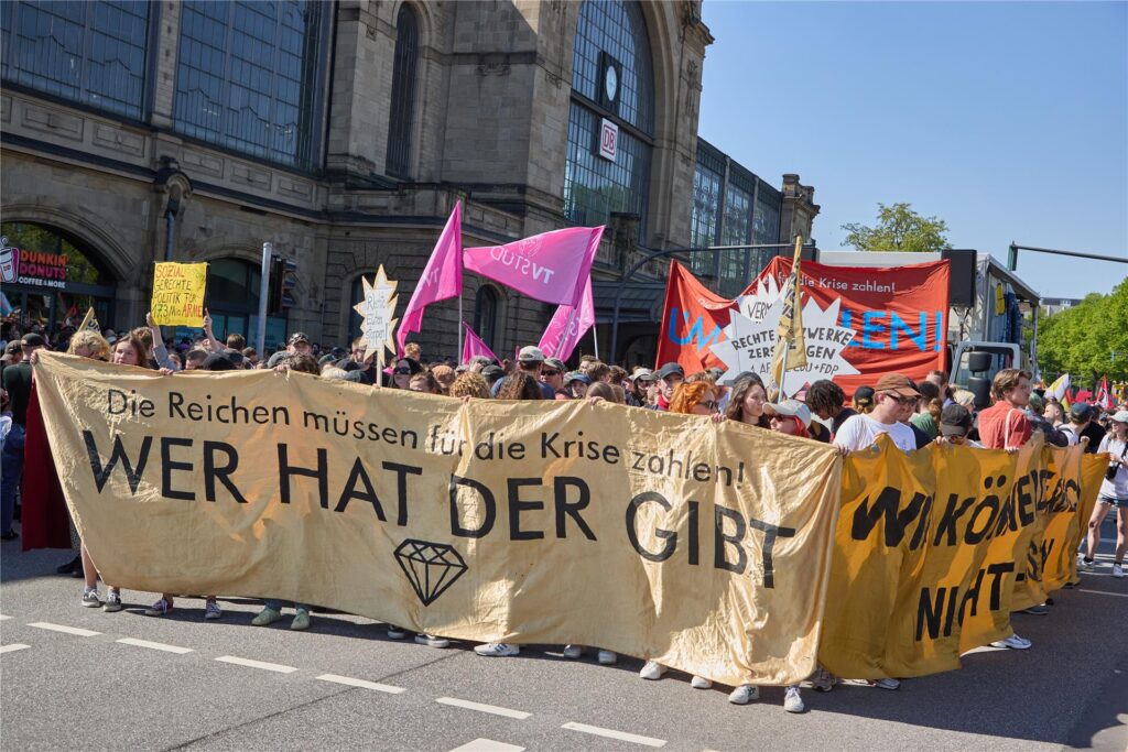 Teilnehmer der Demonstration «Wir haben die Scheiße so satt» vom Bündnis «Wer hat, der gibt» halten am Hamburger Bahnhof Dammtor ein Transparent mit der Aufschrift: «„Die Reichen müssen für die Krise zahlen! Wer hat, der gibt“. Teilnehmer der Demonstration «Wir haben die Scheiße so satt» vom Bündnis «Wer hat, der gibt» halten am Hamburger Bahnhof Dammtor ein Transparent mit der Aufschrift: «„Die Reichen müssen für die Krise zahlen! Wer hat, der gibt“.