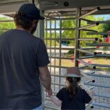 Ein Vater und seine Tochter stehen vor dem geschlossenen Eingang zum Freibad Wellinghofen.