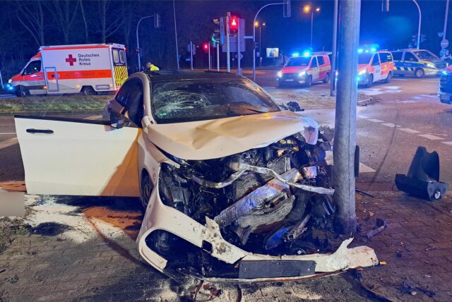 Ein zerstörtes Auto steht nach einem Unfall an der Herzlia-Allee in Marl vor einem Ampelmast.