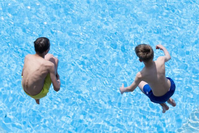 Symbolbild zeigt Kinder, die ins Wasser springen.