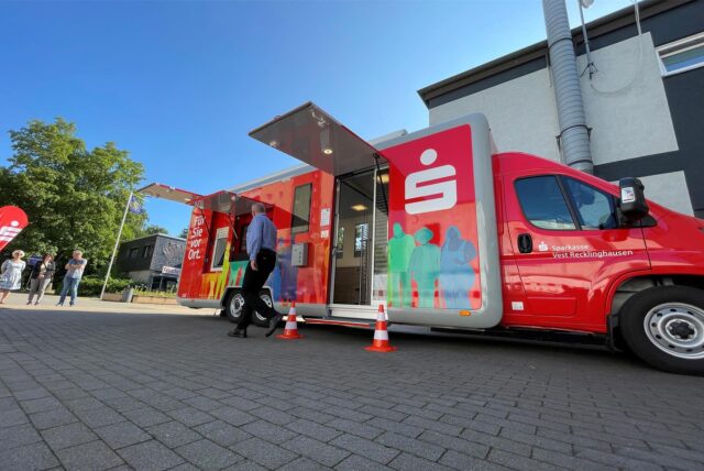 Bild des Sparkassen-Busses auf einem gepflasterten Platz.