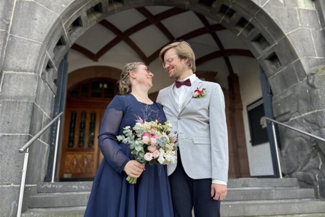 Zwei Menschen, die geheiratet haben, stehen vor dem Rathaus in Recklinghausen.