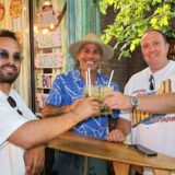 Drei Männer stoßen mit Cocktails an