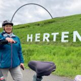 Die Hertenerin Petra Laugell steht an ihrem Fahrrad vor dem Herten-Schriftzug auf der Halde Hoheward.