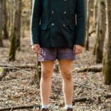 Mann steht in Unterhose im Wald.