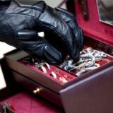 Eine Hand greift nach Schmuck aus einer Schatulle.