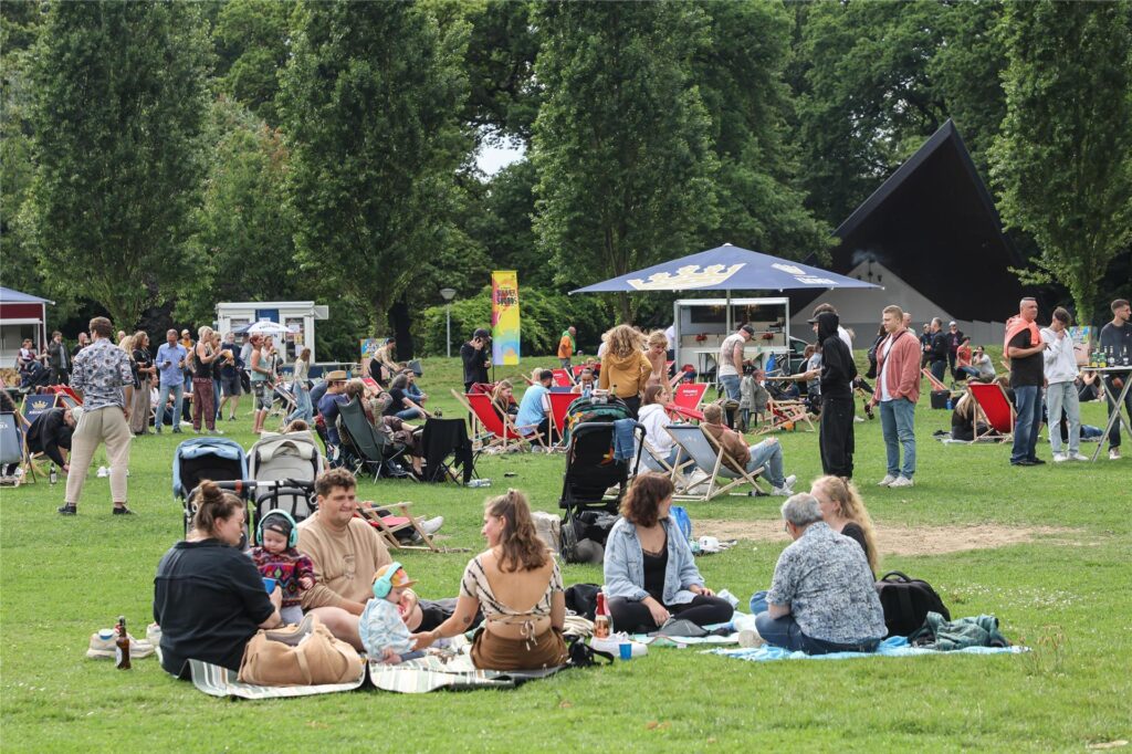 Im Fredenbaumpark in Dortmund machen es sich Menschen mit Picknickdecken im Freien bequem.
