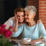 Eine junge Frau nimmt am Muttertag ihre Mutter in den Arm.