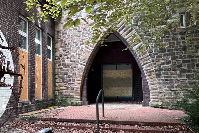 Haupteingang der entweihten Christuskirche an der Bahnhofstraße in Herten-Bertlich mit Brettern vor Türen und Fenstern