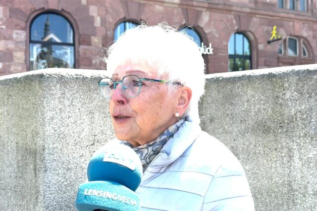 Eine Frau spricht auf dem Hansaplatz in Dortmund in ein Mikrofon.
