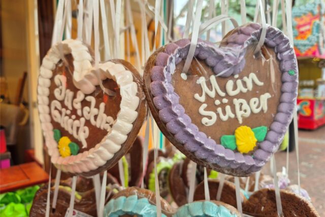 Lebkuchenherzen hängen in einem Kirmeswagen.