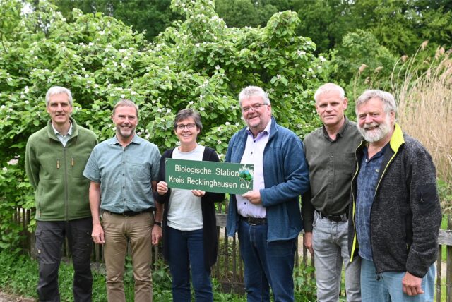 Gruppenbild mit grünem Schild „Biologische Station Kreis Recklinghausen e.V.“