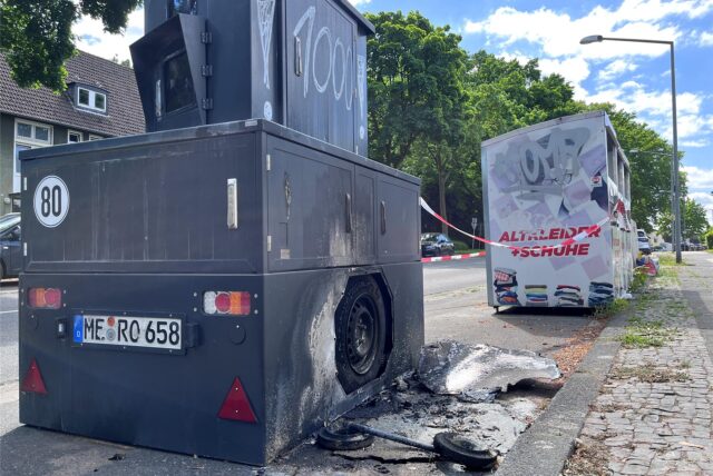 Der Panzerblitzer an der Langenbochumer Straße wurde an einer Seite Opfer der Flammen, das Rad des Anhängers brannte. Die Verkleidung liegt verrußt davor.