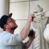 Ein Mitarbeiter des Steinmetz-Betriebs aus Coesfeld, setzt den Knauf des Schwertes neu an.
