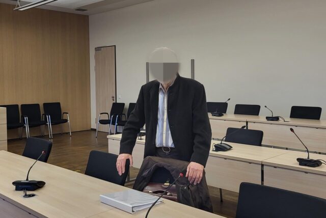 Ein Mann steht in einem Gerichtssaal.