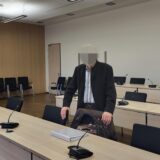 Ein Mann steht in einem Gerichtssaal.