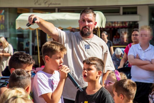 Rapper Seba aus Herten singt bei einer Veranstaltung mit mehreren Kindern.