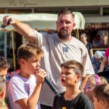 Rapper Seba aus Herten singt bei einer Veranstaltung mit mehreren Kindern.