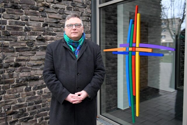 Claus Althoff, der Pfarreiratsvorsitzender der Pfarrei Heilige Edith Stein, steht vor dem Eingang der Pfarrei.