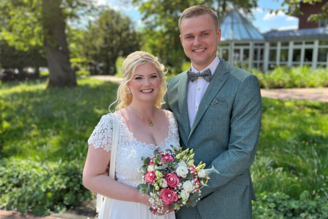 Gianna Ternieden Mehrwald und Maik Mehrwald stehen als Hochzeitspaar vor der Kamera.