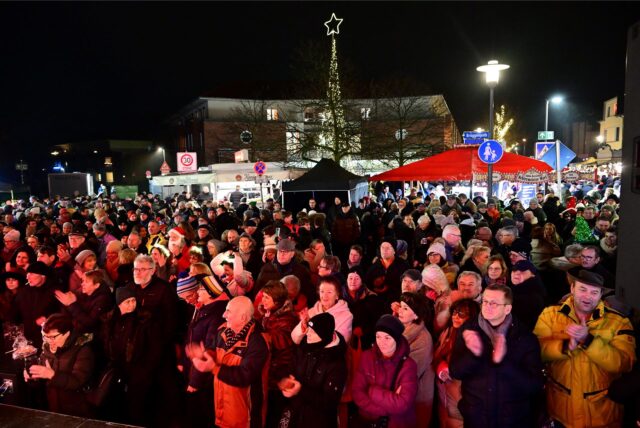 Das Dorf tanzt. Beim Polsumer Weihnachtsmarkt stehen Menschen in der Dunkelheit vor einer Bühne und feiern.