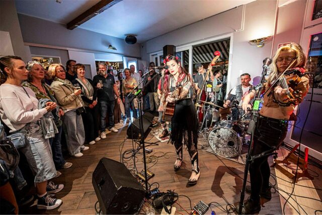 Besucher der White Night in Haltern schauen beim Auftritt von Mary Lee Family Band im Alten Gasthaus Döbber zu.