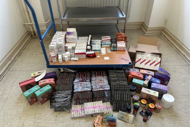 Rund um einen Lastenwagen sind verschreibungspflichtige Medikamente, illegales Feuerwerk und Drogen gestapelt.
