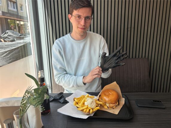 WZ-Autor Valentin Schneider sitzt auf einer Sitzbank bei ToksFood in Waltrop.