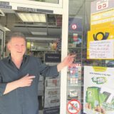 Kiosk-Inhaber Andreas Wendt weist auf ein Hinweisschild an der Tür.