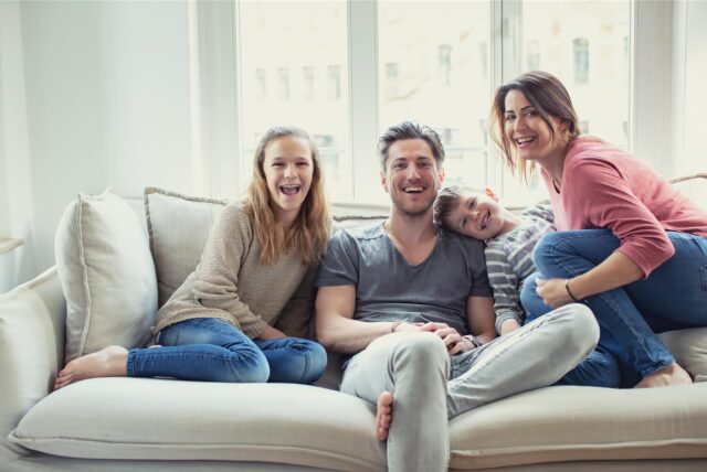 Eine Familie sitzt auf einem Sofa.