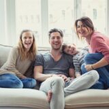 Eine Familie sitzt auf einem Sofa.
