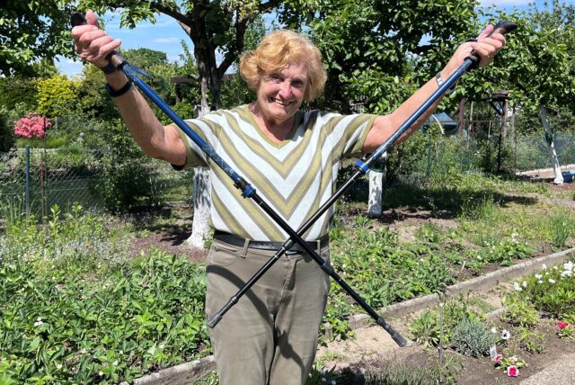 Topfit und beweglich: Marianne Kupczyk nimmt fürs Foto in ihrem geliebten Kleingarten bereitwillig die Wanderstöcke in die Hand.