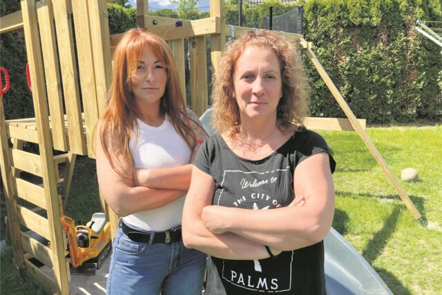 Zwei junge Frauen mit verschränkten Armen vor dem Spielgerät.