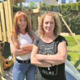 Zwei junge Frauen mit verschränkten Armen vor dem Spielgerät.