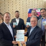 AWO-Quartiersmeister Stefan Schmitz (vorne r.) empfängt den Förderbescheid über 413.000 Euro aus den Händen von Marco Schmitz (vorne l.) Viel Erfolg wünschen dem Projekt (v. l.) die leitenden AWO-Mitarbeiter Ann-Katrin Purck, Felix Groß, AWO-Geschäftsführer Westliches Westfalen Uwe Hildebrand sowie AWO Abteilungsleiter Markus Wallmeier.