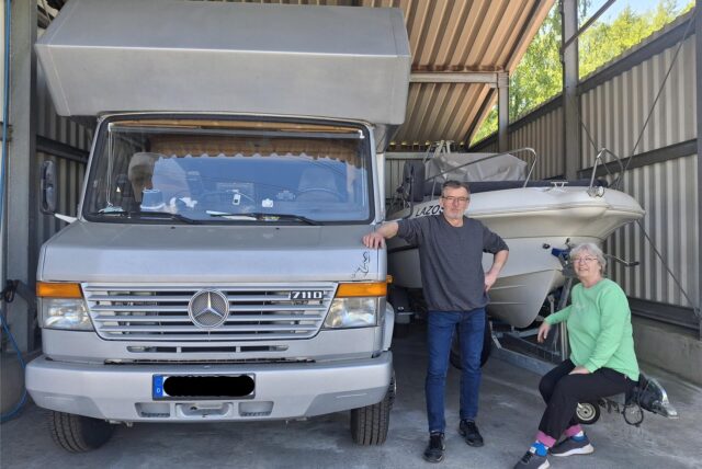 Stefan und Karin stehen vor ihrem Boot und Wohnmobil auf ihrem Parkplatz