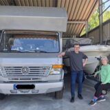 Stefan und Karin stehen vor ihrem Boot und Wohnmobil auf ihrem Parkplatz